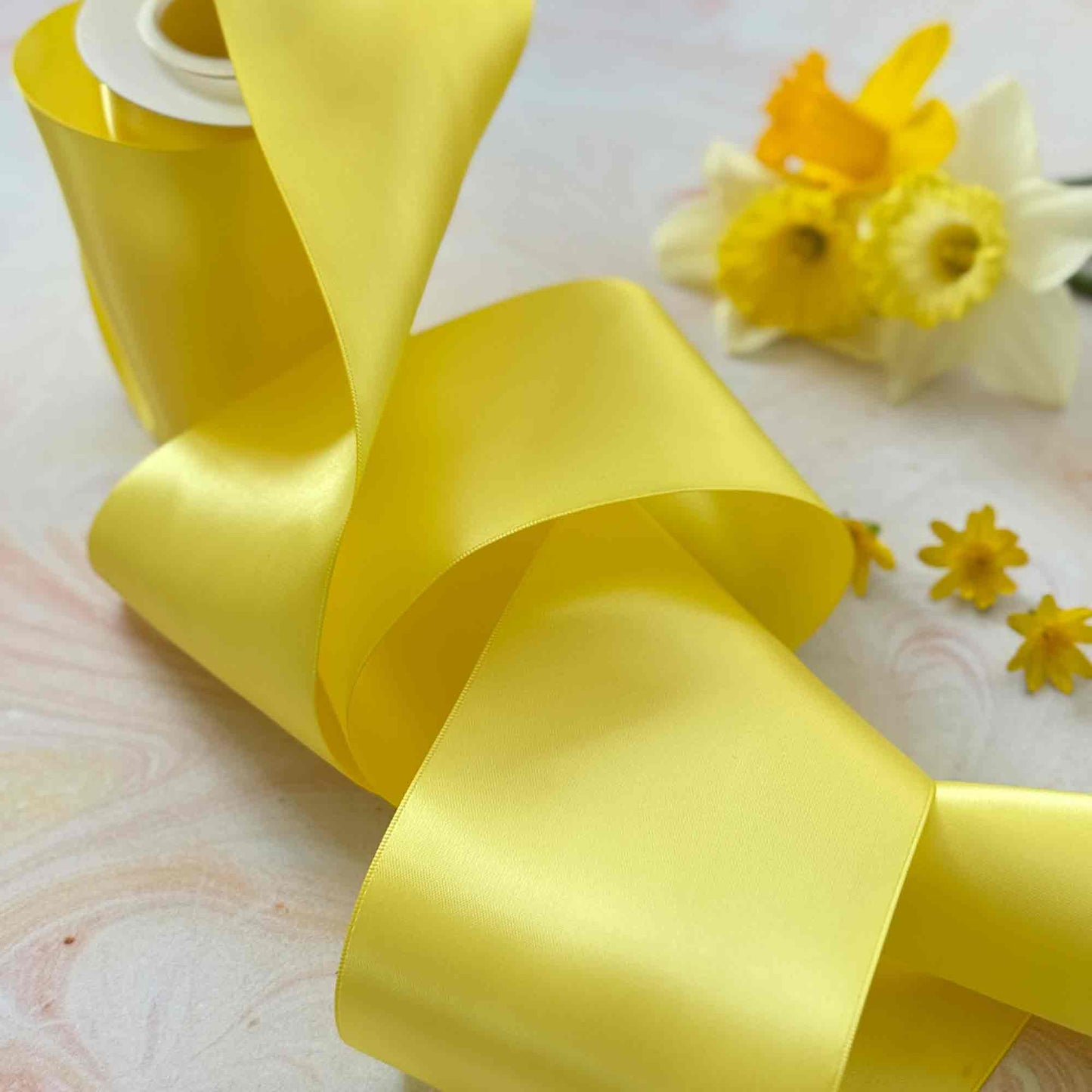 Extra wide satin ribbon in lemon yellow. 10cm wide. 100mm wide. Sold in 10 meter rolls or in 1 metre lengths. Perfect for chair covers.