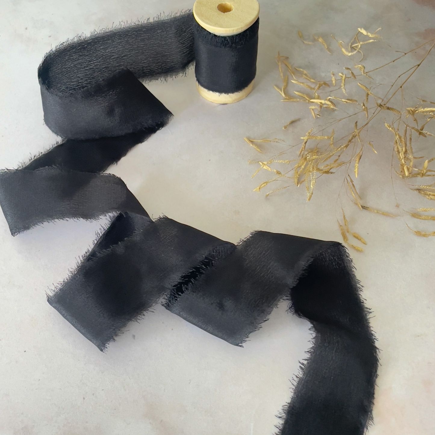 black-silk-ribbon-on-wooden-reel